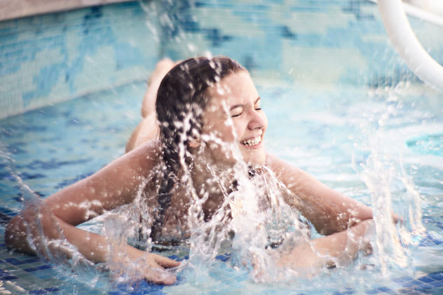 Young girl playing in splash zone.